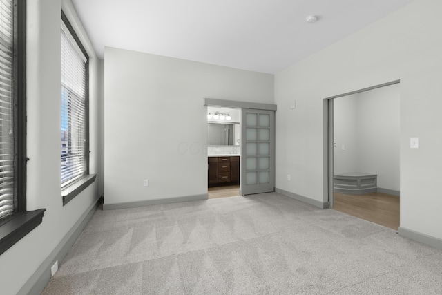 51 N High St Unit 408, Columbus, OH 43215 - unfurnished bedroom featuring light carpet, baseboards, and connected bathroom