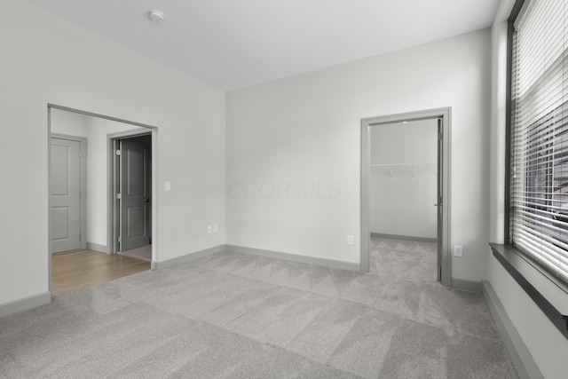 51 N High St Unit 408, Columbus, OH 43215 - unfurnished bedroom featuring carpet, a spacious closet, baseboards, and a closet
