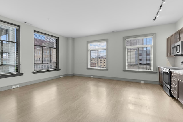 51 N High St Unit 408, Columbus, OH 43215 - unfurnished living room with light wood finished floors, rail lighting, and baseboards