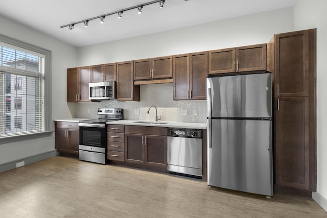 51 N High St Unit 408, Columbus, OH 43215 - kitchen featuring appliances with stainless steel finishes, light countertops, a sink, track lighting, and backsplash