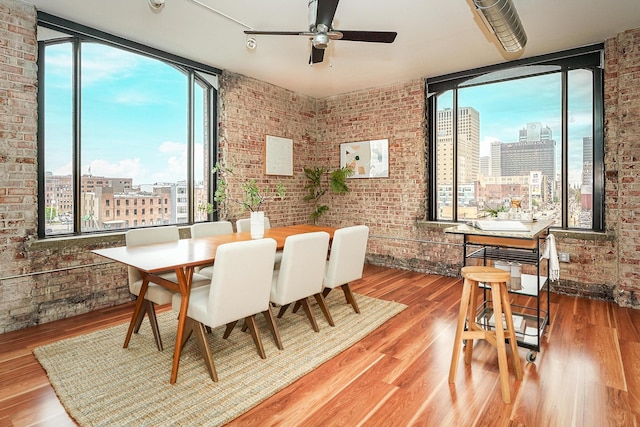 dining space featuring ceiling fan, a view of city, and a healthy amount of sunlight