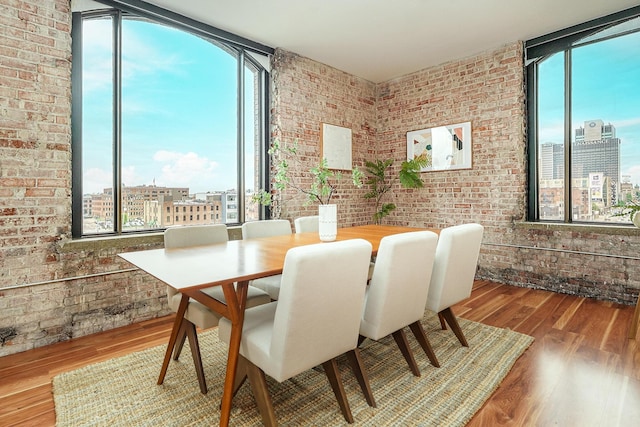 dining room featuring plenty of natural light, a wall of windows, and a view of city