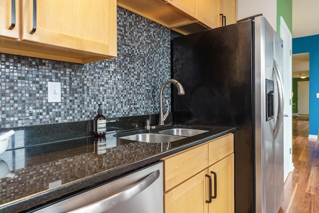 kitchen with a sink, dishwasher, decorative backsplash, light brown cabinets, and light wood-style floors