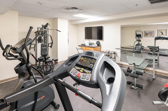 workout area with a paneled ceiling, baseboards, and visible vents