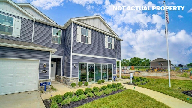 view of front of home featuring stone siding, a garage, fence, a front lawn, and board and batten siding