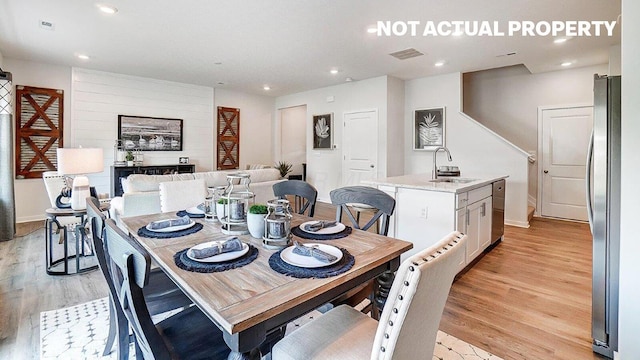 dining room featuring light wood-style flooring, baseboards, visible vents, and recessed lighting