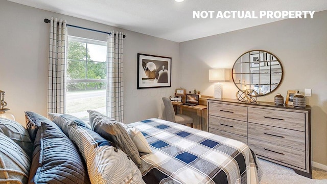 bedroom featuring light colored carpet and baseboards
