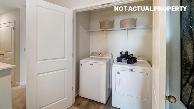 clothes washing area featuring separate washer and dryer and laundry area