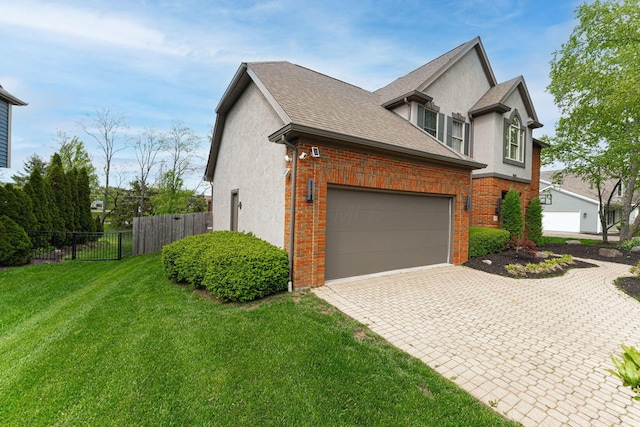 view of property exterior with stucco siding, driveway, an attached garage, brick siding, and roof with shingles