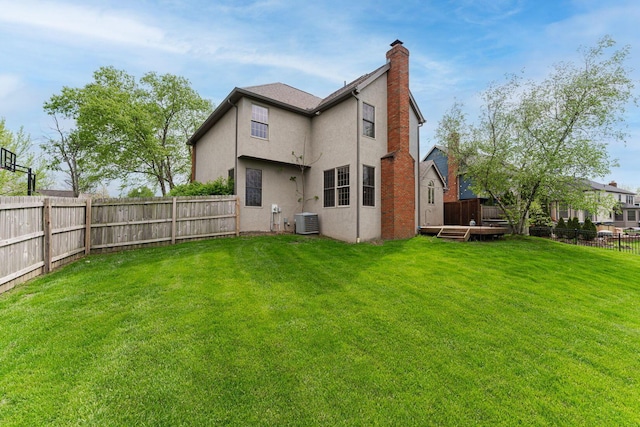 rear view of property with a chimney, central AC unit, and stucco siding