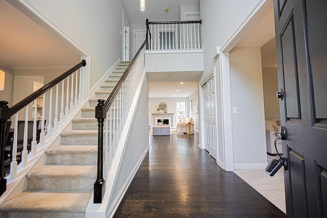 382 Beecher Rd, Columbus, OH 43230 - entrance foyer featuring stairway, wood finished floors, a high ceiling, a fireplace, and baseboards