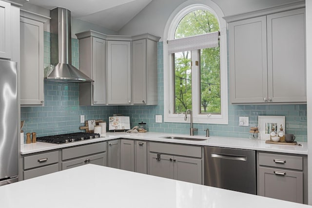 382 Beecher Rd, Columbus, OH 43230 - kitchen featuring gray cabinetry, a sink, appliances with stainless steel finishes, wall chimney exhaust hood, and lofted ceiling