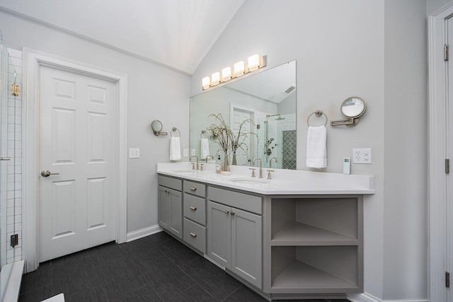 382 Beecher Rd, Columbus, OH 43230 - full bathroom featuring double vanity, lofted ceiling, a tile shower, baseboards, and tile patterned flooring