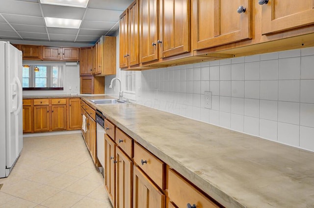 668 Enfield Rd, Columbus, OH 43209 - kitchen featuring a sink, white refrigerator with ice dispenser, brown cabinetry, tasteful backsplash, and light countertops