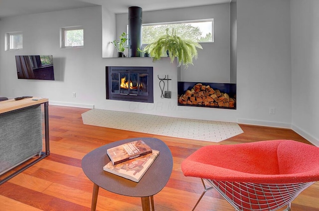 668 Enfield Rd, Columbus, OH 43209 - living area with healthy amount of natural light, a glass covered fireplace, baseboards, and wood finished floors