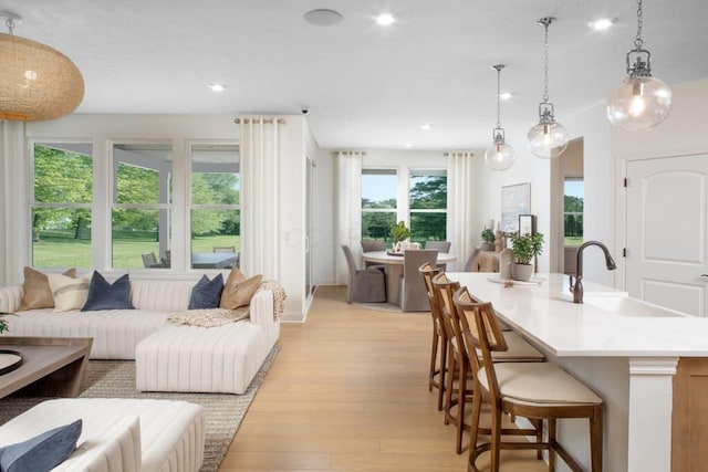 interior space featuring recessed lighting, light wood-type flooring, open floor plan, and a sink