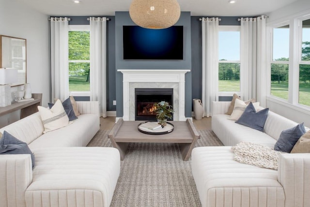 living room with a premium fireplace, baseboards, recessed lighting, and wood finished floors