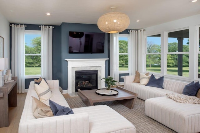 living area with a fireplace, recessed lighting, baseboards, and wood finished floors