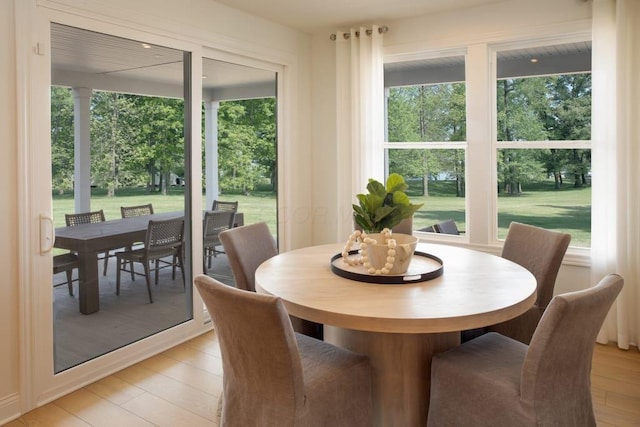 dining area with light wood-style flooring and a healthy amount of sunlight