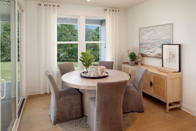 dining room featuring baseboards, recessed lighting, light wood-type flooring, and plenty of natural light
