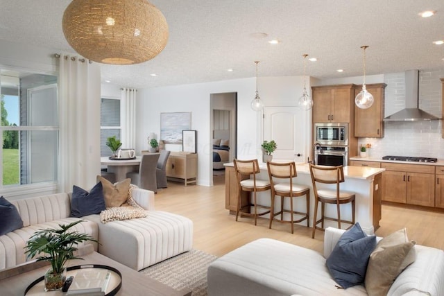 living room with light wood-type flooring and recessed lighting