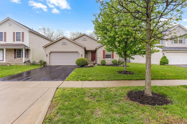 2099 Winding Hollow Dr, Grove City, OH 43123 - traditional-style house featuring a front yard, a garage, stone siding, and driveway