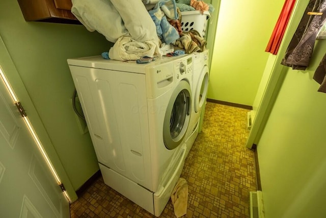 washroom featuring washer and dryer, cabinet space, and baseboards