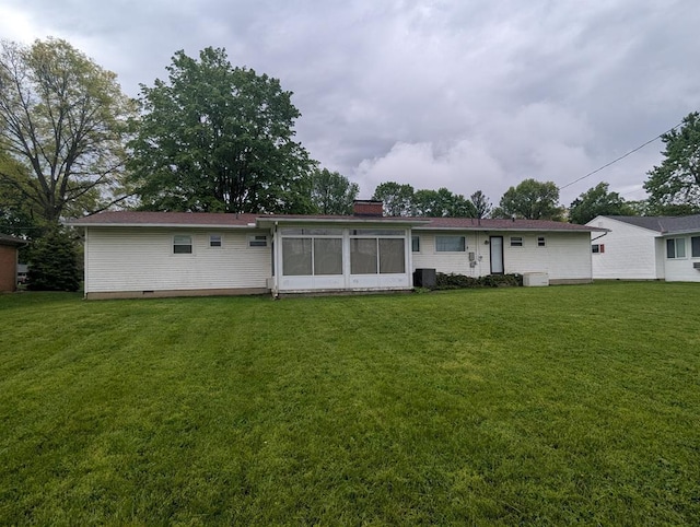 back of property featuring a yard and a sunroom