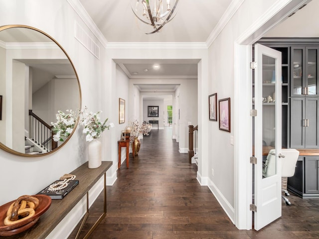 hall with an inviting chandelier, crown molding, visible vents, dark wood-type flooring, and stairs