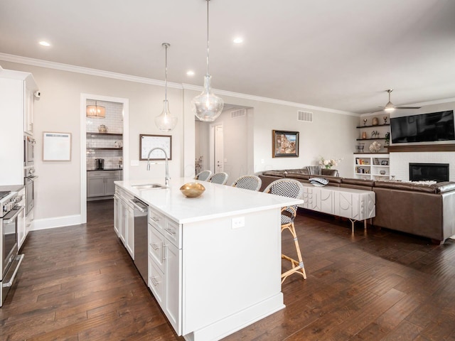 kitchen with visible vents, a sink, a kitchen breakfast bar, crown molding, and stainless steel appliances