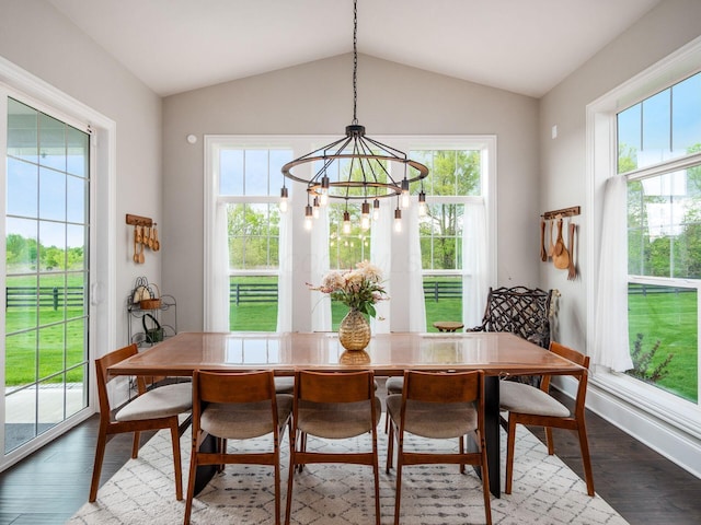 dining space featuring a wealth of natural light, vaulted ceiling, and a notable chandelier
