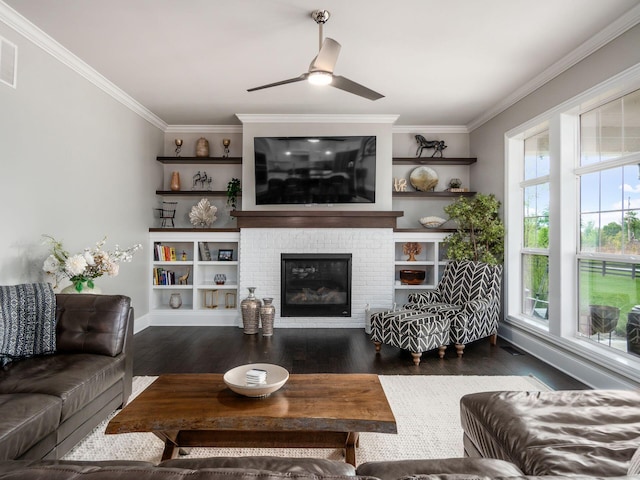 living room with built in shelves, crown molding, and wood finished floors