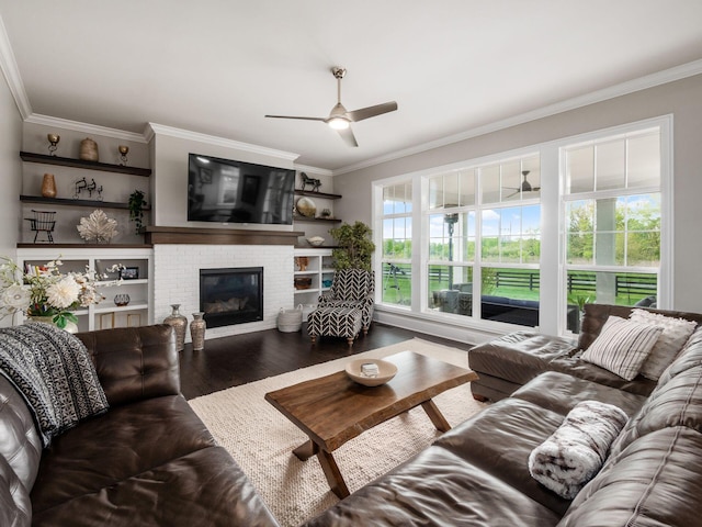 living area featuring a fireplace, ornamental molding, a ceiling fan, and wood finished floors