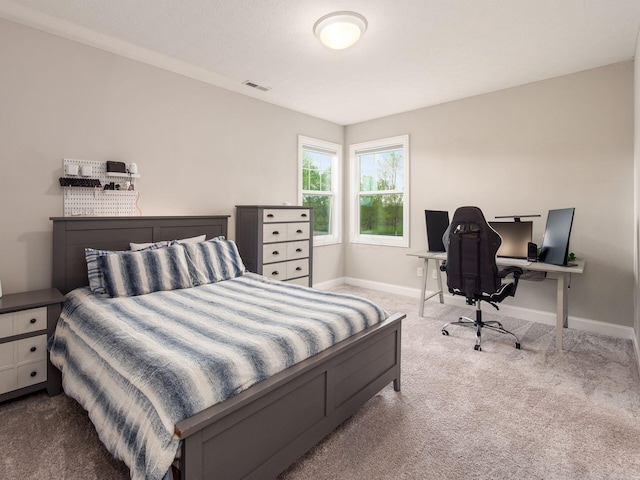 bedroom with baseboards, visible vents, and carpet