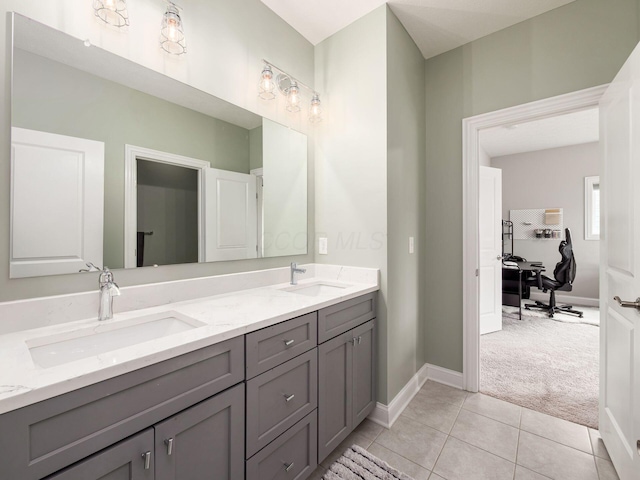 full bath with baseboards, double vanity, and a sink