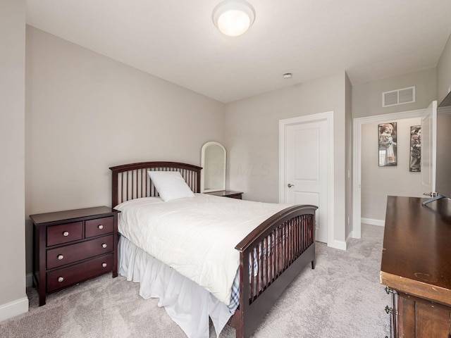 bedroom with light colored carpet, visible vents, and baseboards