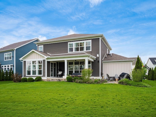 back of house featuring board and batten siding, a patio, a ceiling fan, and a lawn