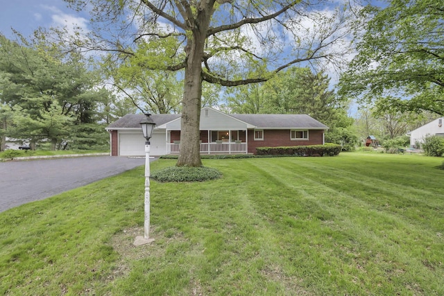 ranch-style house with covered porch, brick siding, driveway, and an attached garage