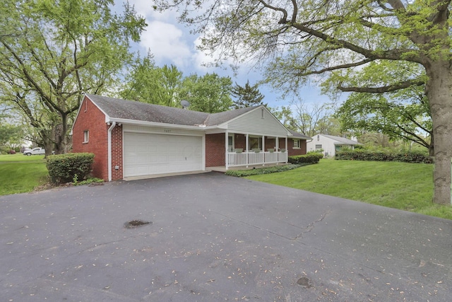 ranch-style house featuring covered porch, brick siding, a garage, driveway, and a front lawn