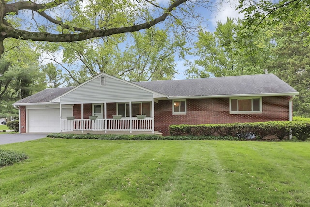 ranch-style house with brick siding, an attached garage, a front yard, and covered porch