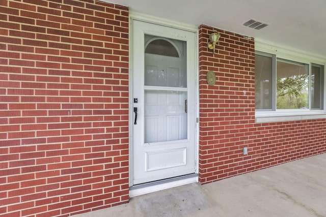 doorway to property with brick siding