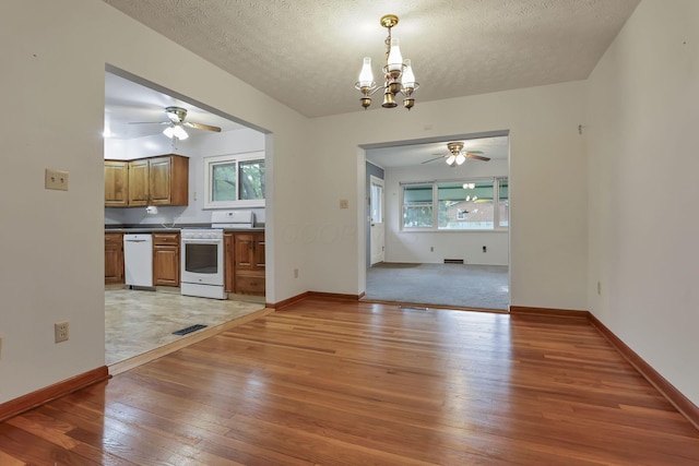 kitchen with white appliances, light wood-style flooring, ceiling fan, brown cabinetry, and a textured ceiling