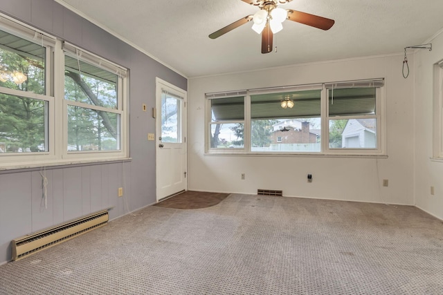 empty room with baseboard heating, carpet flooring, ornamental molding, and a ceiling fan