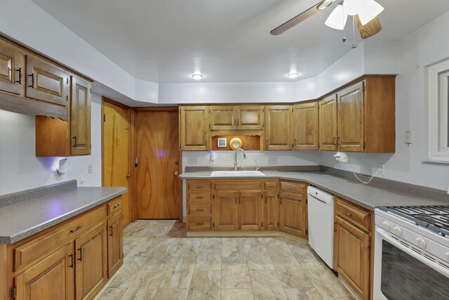 kitchen with white appliances, a sink, a ceiling fan, and brown cabinets