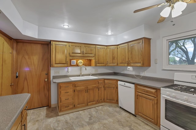 kitchen featuring white appliances, a sink, brown cabinets, and a ceiling fan