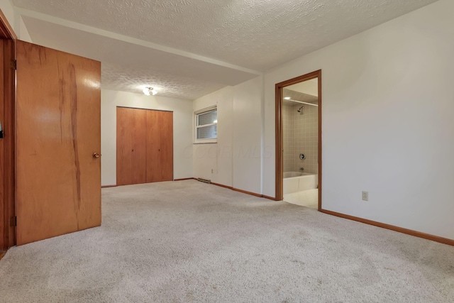 unfurnished room featuring a textured ceiling, baseboards, and light colored carpet