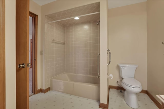 bathroom with tile patterned floors, toilet, baseboards, and shower / washtub combination