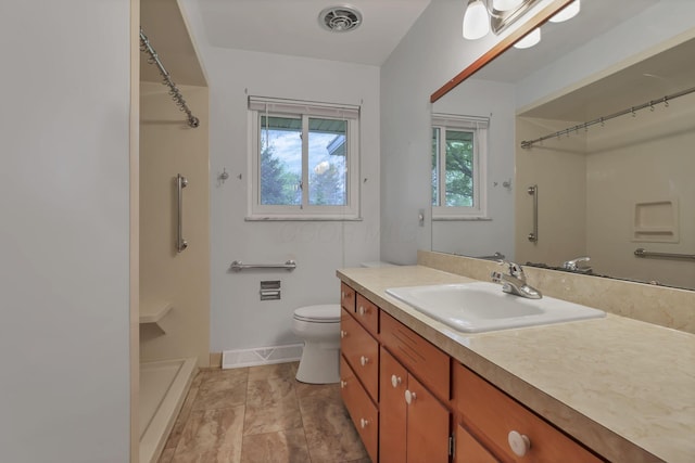 full bathroom featuring a shower, vanity, toilet, and baseboards
