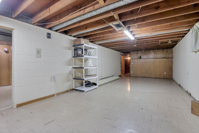 unfinished below grade area with light flooring and concrete block wall