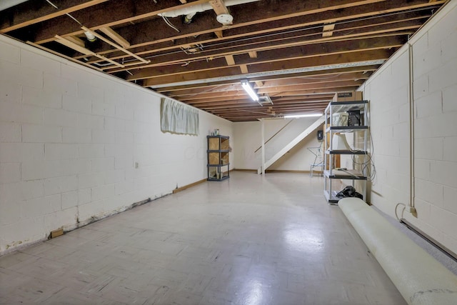 unfinished below grade area featuring tile patterned floors and concrete block wall